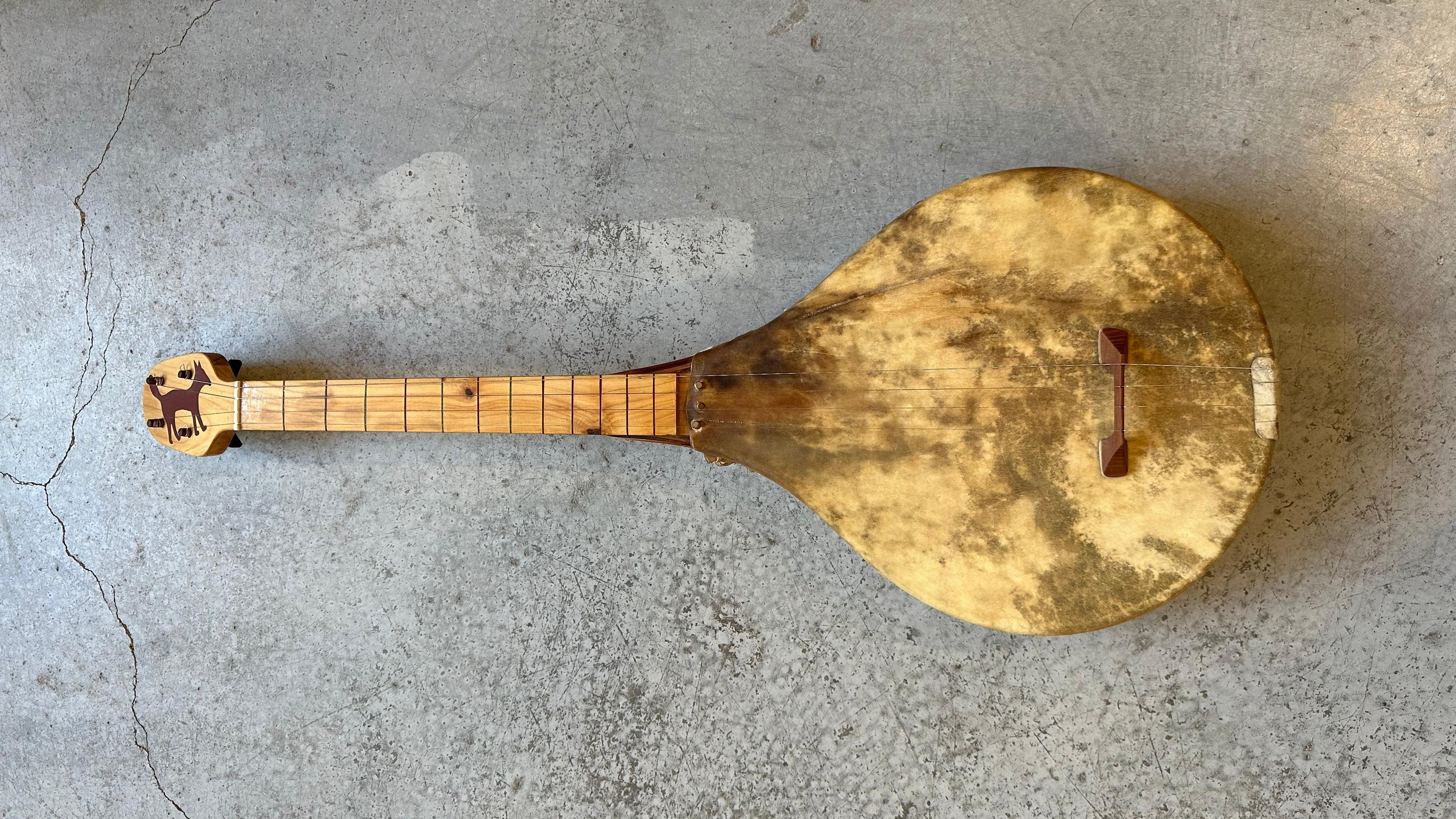 Deer Hide & Eastern red cedar Banjo with a cat wooden inlay at the tuning board.